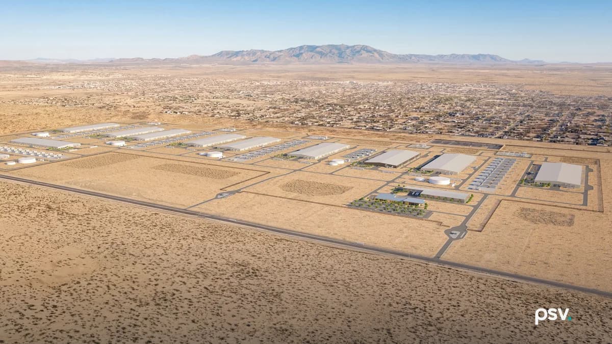 Aerial rendering of a data center campus laid out on flat desert ground: rows of long low white buildings separated by wide access roads and graded pads, circular water tanks and rows of grey equipment enclosures along one edge, a landscaped low office building with a parking lot in the foreground, and an El Paso residential neighborhood and a mountain ridge on the horizon behind it
