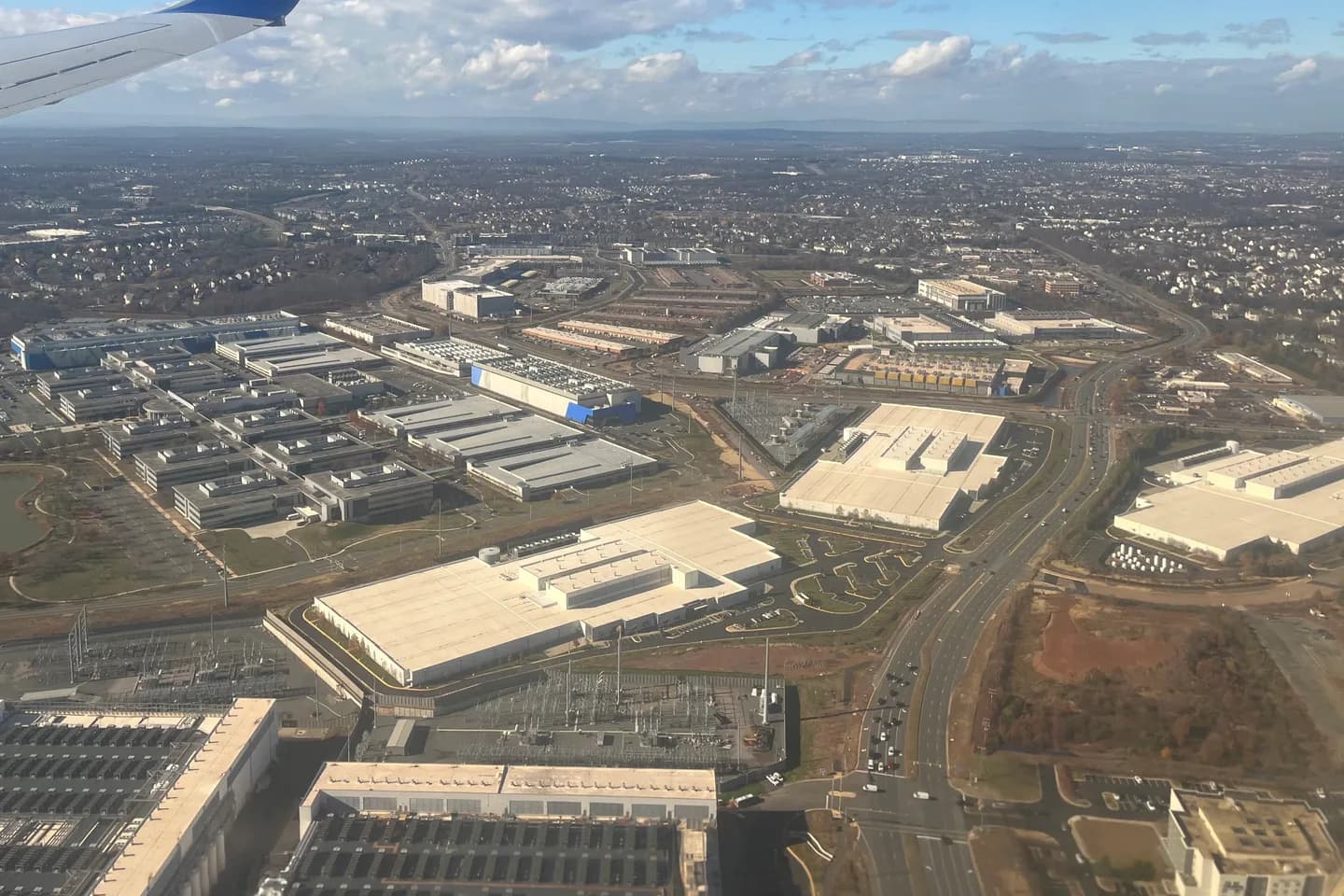 Aerial view of Loudoun County, Virginia: rows of long, flat-roofed data center buildings with rooftop cooling units, set among parking lots, service roads and other commercial buildings Aerial view of Loudoun County, Virginia: rows of long, flat-roofed data center buildings with rooftop cooling units, set among parking lots, service roads and other commercial buildings