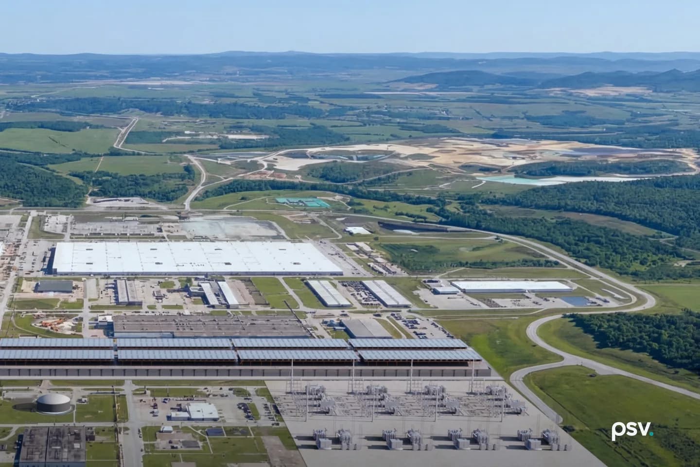 Aerial rendering of the PORTS-Pike Technology Campus in Pike County, Ohio: a long low data center hall with a continuous glazed clerestory roof running across the foreground, a large electrical substation with rows of transformers and transmission gantries immediately beyond it, several existing white-roofed industrial buildings and parking areas of the former uranium enrichment plant behind that, and the wooded ridges and green farmland of southern Ohio stretching to the horizon Aerial rendering of the PORTS-Pike Technology Campus in Pike County, Ohio: a long low data center hall with a continuous glazed clerestory roof running across the foreground, a large electrical substation with rows of transformers and transmission gantries immediately beyond it, several existing white-roofed industrial buildings and parking areas of the former uranium enrichment plant behind that, and the wooded ridges and green farmland of southern Ohio stretching to the horizon